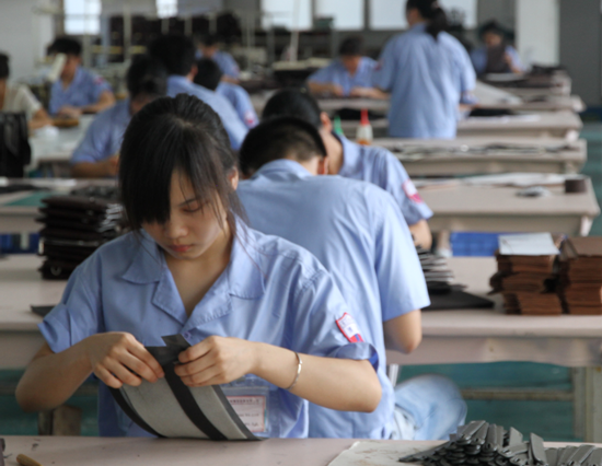 博深皮具廠生產(chǎn)車間員工正使用環(huán)保膠水粘合